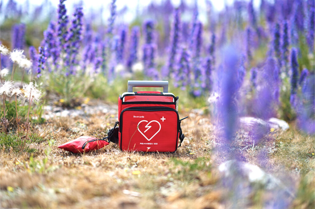 Defibrillator on the ground with bag containing electrodes